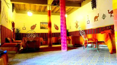 a living room with colorful curtains and chairs at Auberge Camping Ocean des dunes in Merzouga