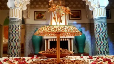 a table topped with a bowl of food and a lamp at Riad Jasmine Sud in Zagora