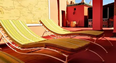 two lounge chairs sitting on a patio with a building at Riad Jasmine Sud in Zagora