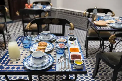 a table with plates of food on top at Algilà Fes Riad Medina Charme Hotel in Fès