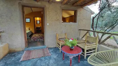 a porch of a house with a table and chairs at Les Jardins de Taja in Ourika