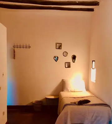 a bedroom with a bed with a cat laying on it at Les Jardins de Taja in Ourika