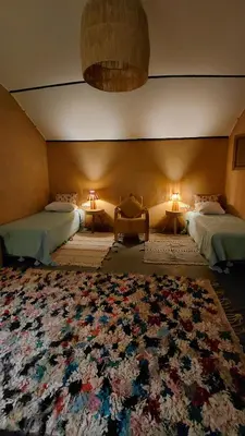 a room with two beds and a large rug at Les Jardins de Taja in Ourika