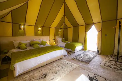 a bedroom with two beds in a tent at Dunes Luxury Camp in Merzouga