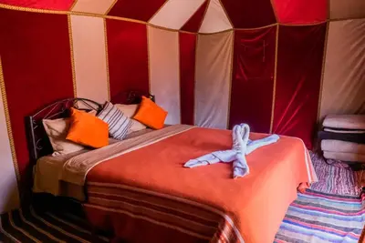 a room with a bed in a tent at Maison Riad Tamarighte in Merzouga