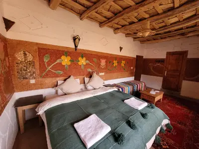 a bedroom with a large bed and a couch in it at Kasbah Chems in Kalaat MGouna