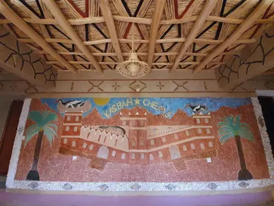 a wall with a painting of a castle and palm trees at Kasbah Chems in Kalaat MGouna
