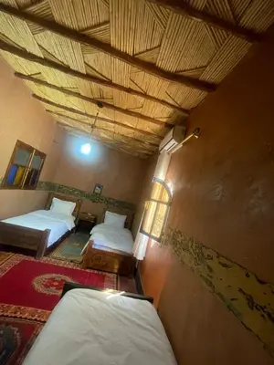 a room with two beds and a wooden ceiling at Dar nadia bendriss in Ouarzazate
