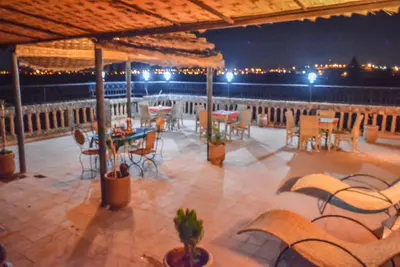 an outdoor patio with tables and chairs at night at Dar nadia bendriss in Ouarzazate