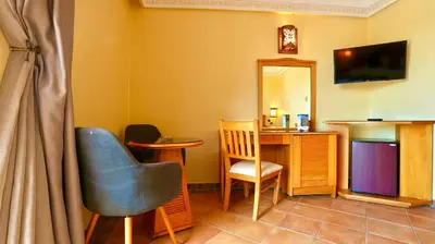 a room with a desk and a chair and a mirror at Hotel Menzeh Dalia in Meknès
