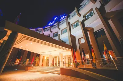 a large building with stairs in front of it at night at Hotel Menzeh Dalia in Meknès