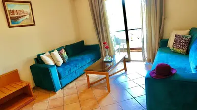 a living room with two blue couches and a table at Hotel Menzeh Dalia in Meknès