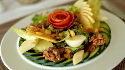 a plate of food with a salad on a table at Hotel Menzeh Dalia in Meknès