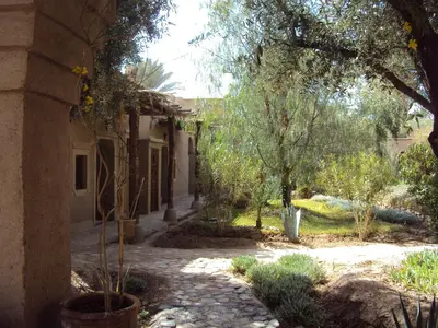a house with a courtyard with trees and a building at Dar Lorkam in Skoura