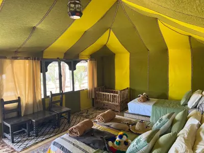 a room with a tent with two beds and a couch at Sahara Majestic Luxury Camp in Merzouga