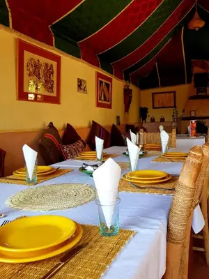 a table with yellow plates and napkins on it at Dar Isselday in Tisselday