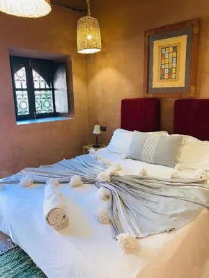 a bedroom with a large bed with towels on it at Dar Isselday in Tisselday