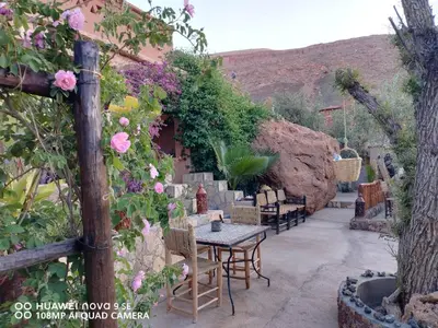 a patio with a table and chairs and flowers at Dar Isselday in Tisselday