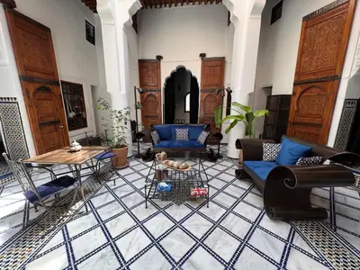 a living room with blue couches and a table at Dar Faracha Fes in Fès