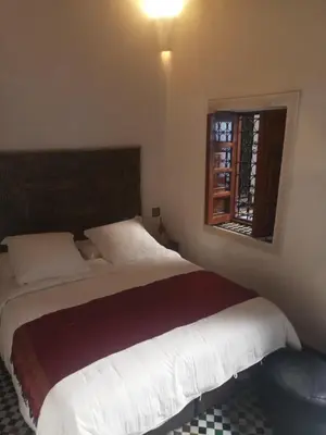 a bedroom with a large bed and a window at Dar Faracha Fes in Fès