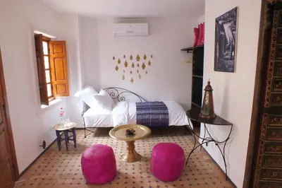 a bedroom with pink chairs and a bed at Dar Faracha Fes in Fès