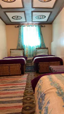 a room with three beds and a window at Kasbah Ait Bouguemez in Agouti