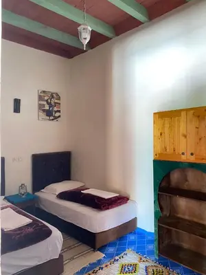 a room with two beds in a room at Kasbah Ait Bouguemez in Agouti