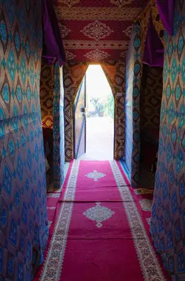 a room with a red carpet and a doorway at Mustapha Camp Merzouga in Merzouga