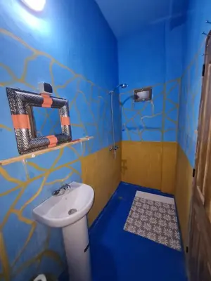 a blue bathroom with a sink and a toilet at Riad Tigmi du Soleil in Aït Ben Haddou