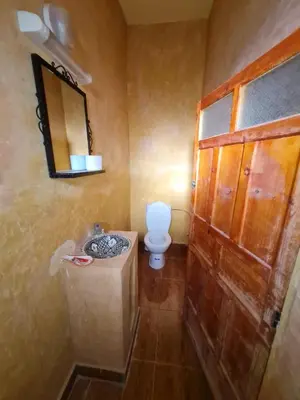 a bathroom with a toilet and a sink and a mirror at Riad Tigmi du Soleil in Aït Ben Haddou