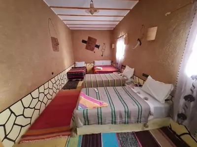 a room with three beds in a room at Riad Tigmi du Soleil in Aït Ben Haddou