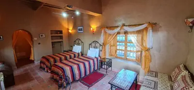 a living room with a bed and a window at Kasbah Ait ben Damiette in Skoura