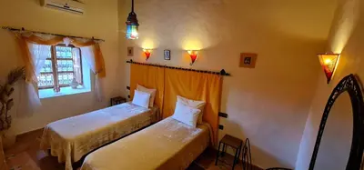 a bedroom with two beds and a window at Kasbah Ait ben Damiette in Skoura