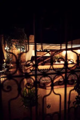 a view through a fence of a patio at night at Chaq Chaq in Fès