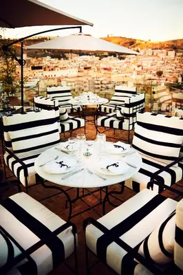 a restaurant with white tables and chairs with a view at Chaq Chaq in Fès