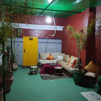 a living room with a couch and a yellow door at Ryad Bab Berdaine in Meknès