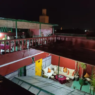 a rooftop bar with couches on a building at night at Ryad Bab Berdaine in Meknès