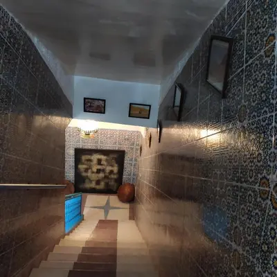 a hallway with a tile floor and a fireplace at Ryad Bab Berdaine in Meknès
