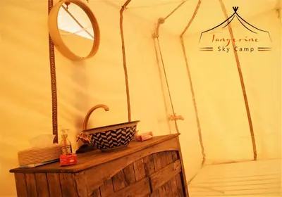 a bathroom with a mirror and a wooden table at Boho Glamping in Merzouga