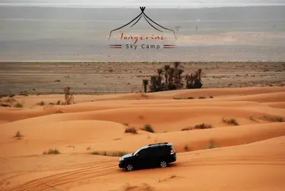 a black suv driving through the desert at Boho Glamping in Merzouga