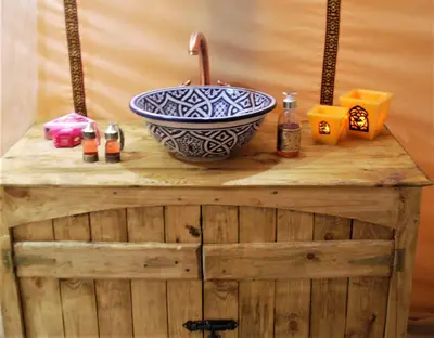 a bowl on top of a wooden table with candles at Boho Glamping in Merzouga
