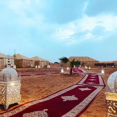 a group of tents in the desert with a red carpet at Boho Glamping in Merzouga