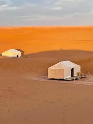 two white tents in the middle of a desert at Sahara Luxury Tents in Merzouga