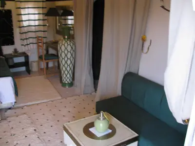 a living room with a green couch and a table at Sahara Luxury Tents in Merzouga