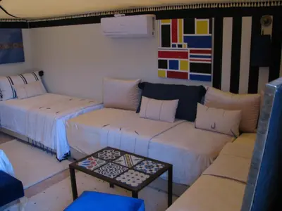 a living room with two couches and a table at Sahara Luxury Tents in Merzouga