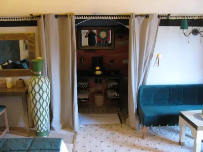a living room with a couch and a tv at Sahara Luxury Tents in Merzouga