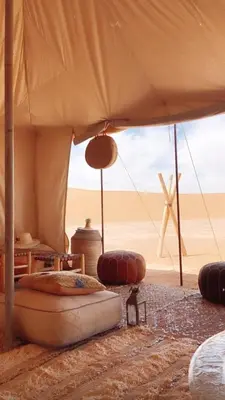 a tent with a bed in the middle of the desert at Sahara Luxury Tents in Merzouga
