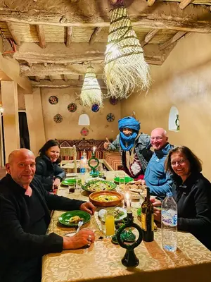 a group of people sitting around a table at Dar Nomads in Mhamid