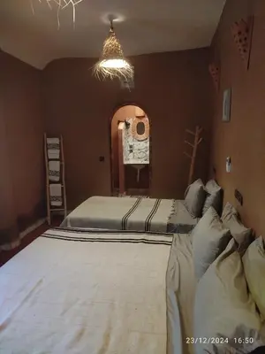 a bedroom with two beds and a chandelier at Dar Nomads in Mhamid