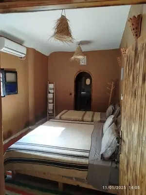 a bedroom with a large bed in a room at Dar Nomads in Mhamid